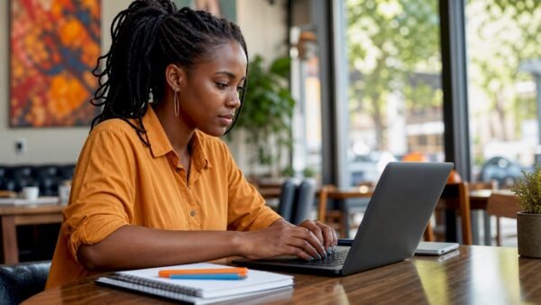 Young woman building cybersecurity portfolio at desk