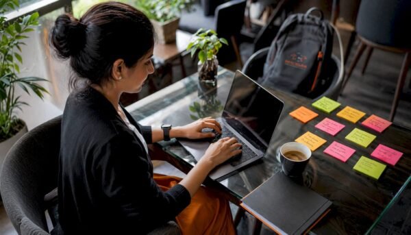 Woman typing cybersecurity resume at home desk
