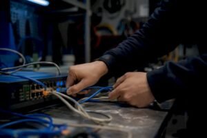 Hands connecting network cables in lab