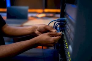 Hands connecting network cable to lab equipment