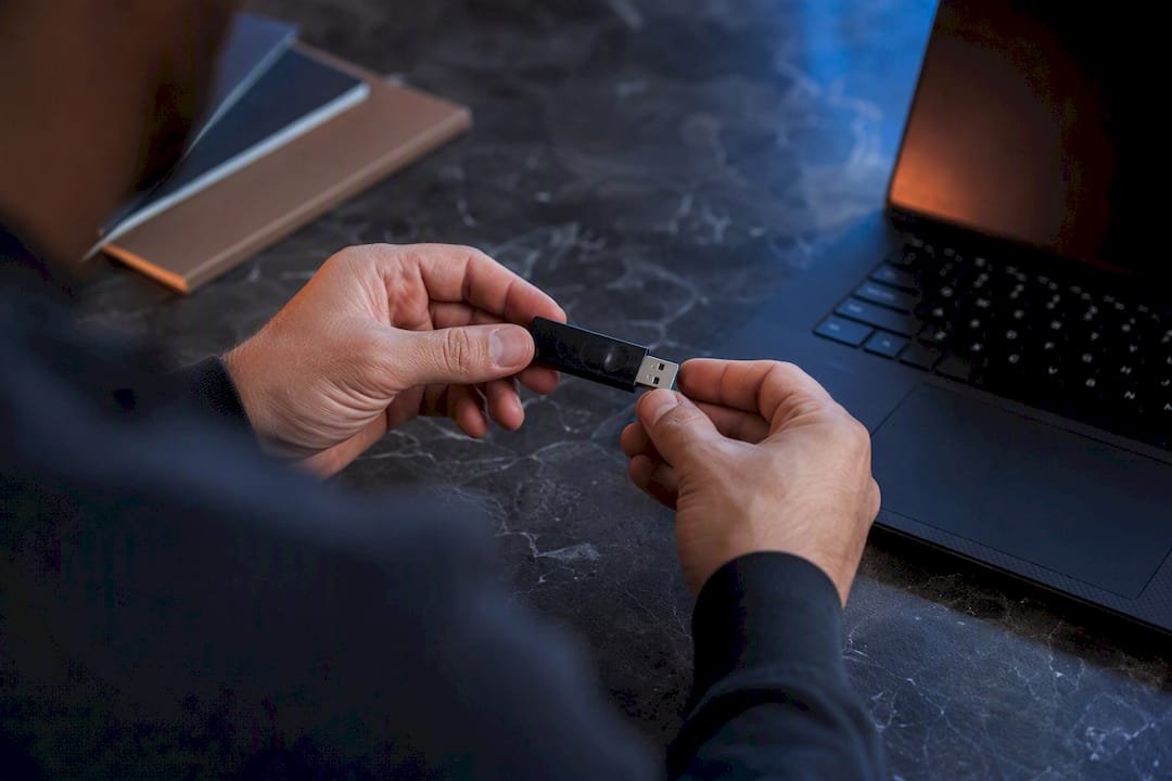 Hands examining USB device for cyber attack