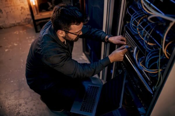 Hands connecting network cable in cybersecurity lab