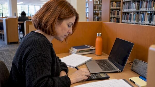 Learner practicing subnetting at a library carrel
